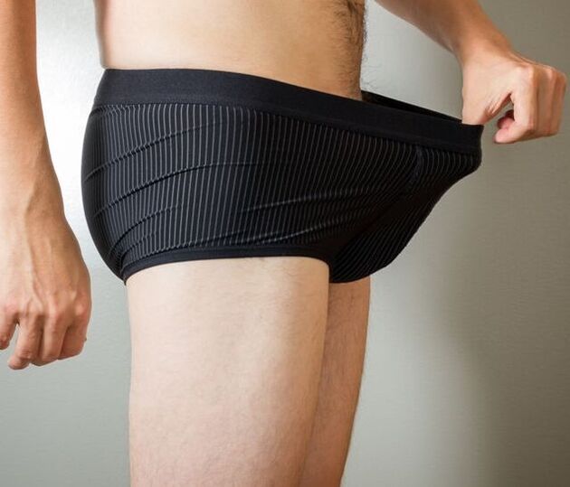 A man looks into his underwear after penis enlargement surgery
